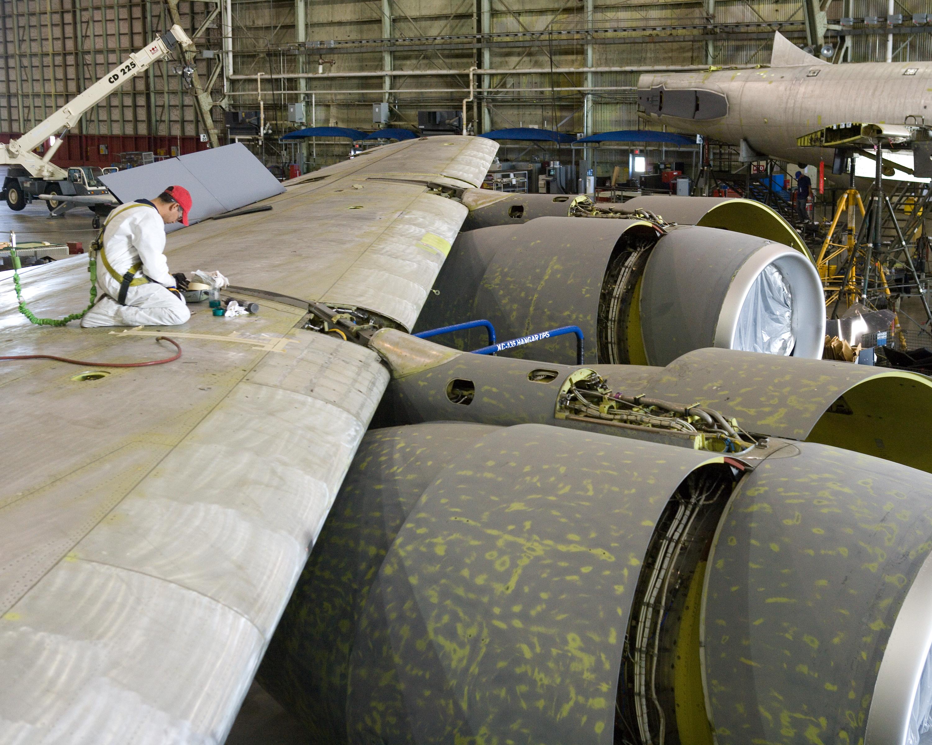 A NAAS & Accessories MRO technician performing a repair on a wing of an aircraft.